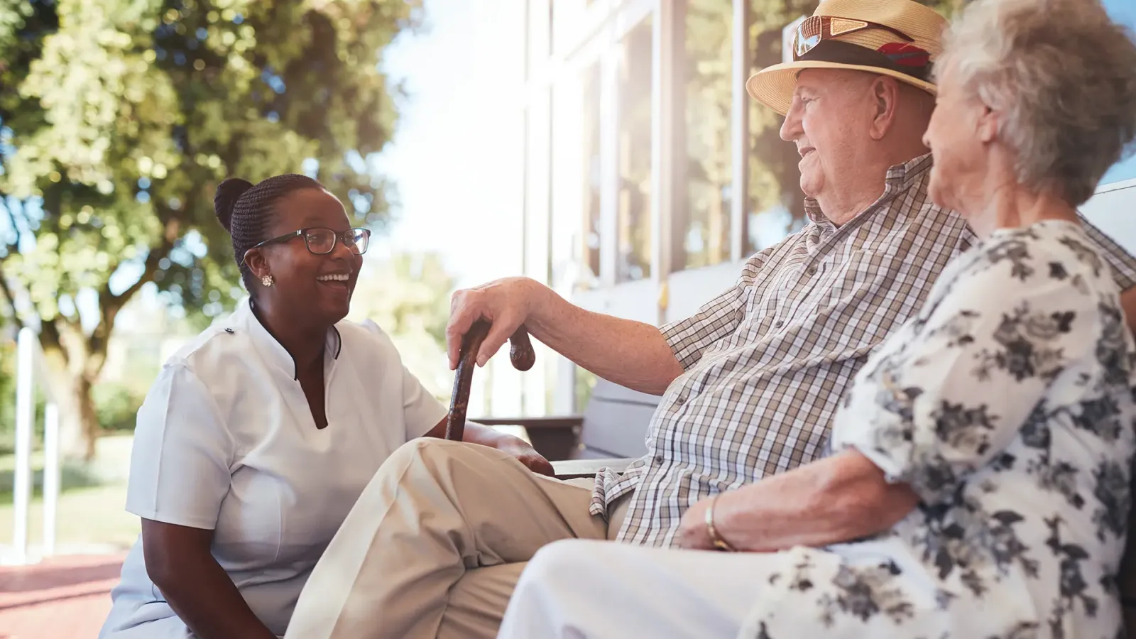 nurse talking with elderly couple outdoors